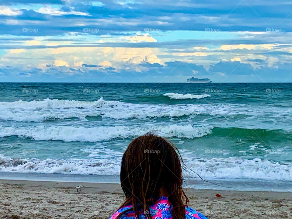 Child Enjoying The Beach Watching The Atlantic Ocean Waves And A Windy And Cloudy Day Seeing A Ship In The Horizon And Observing Cumulonimbus And Cirrostratus Clouds. 