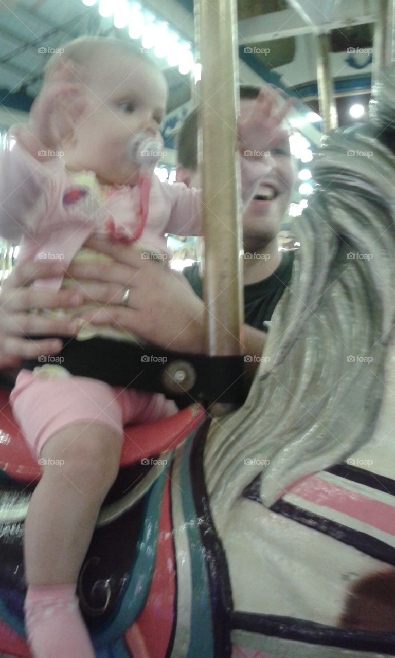 Carousel. Playing on the merry go round. she wasn't a big fan.