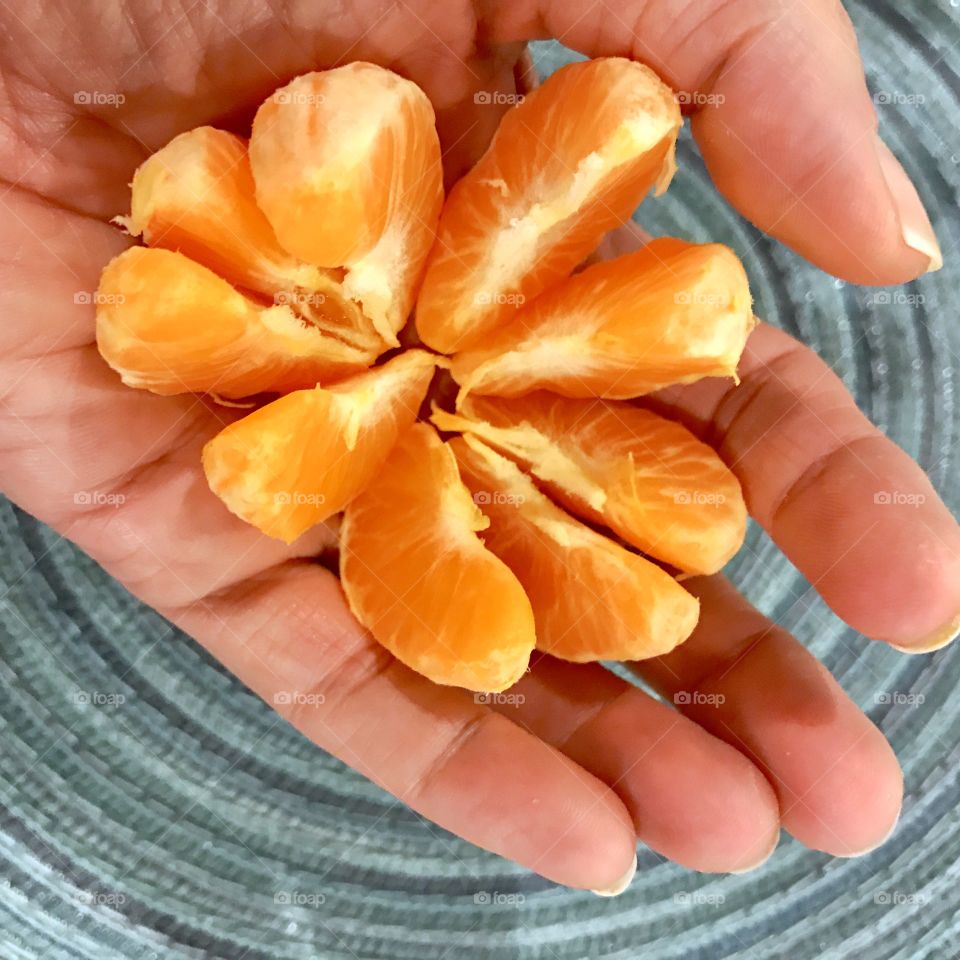 Close-up of a orange slice in hand