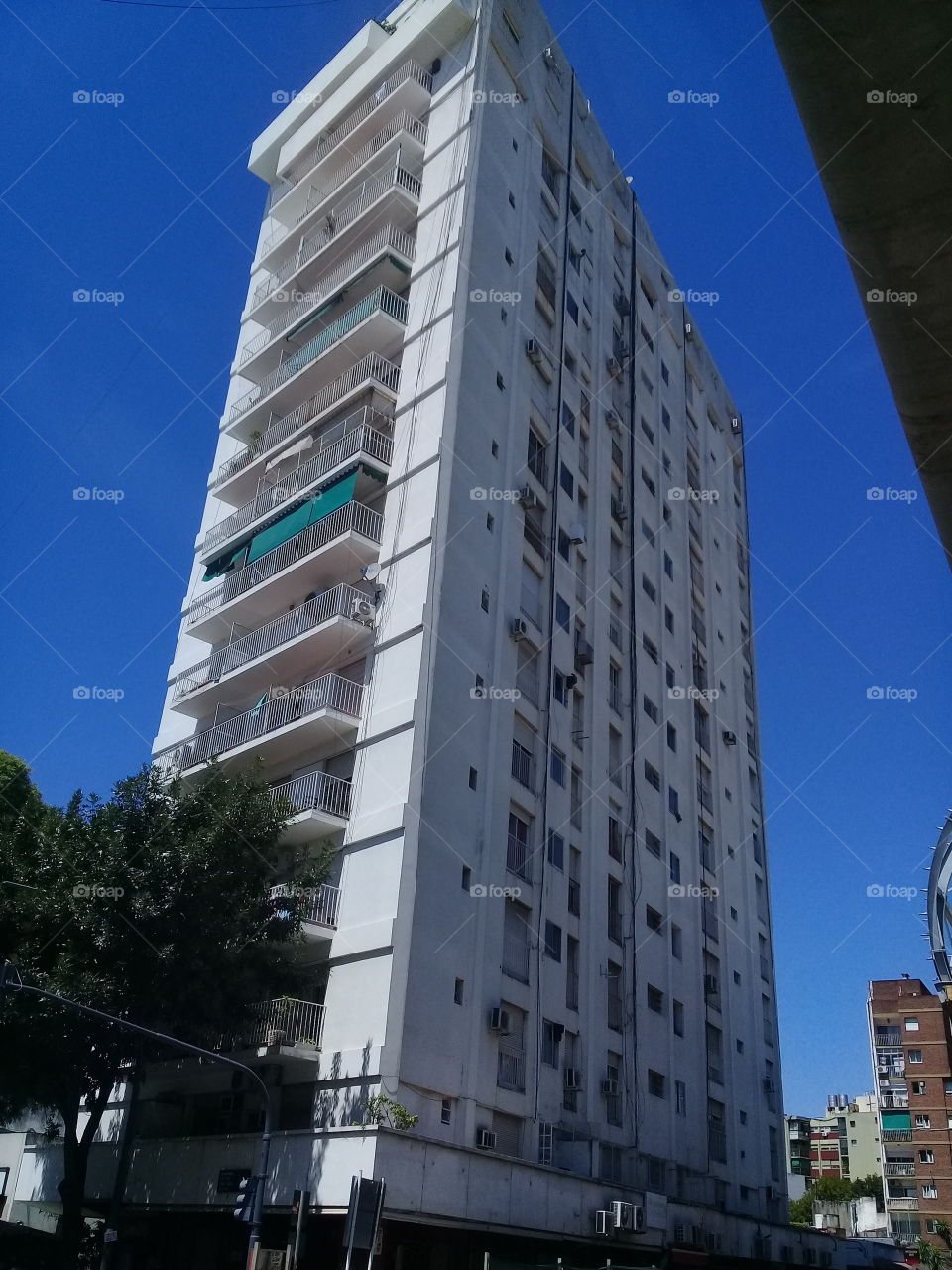 imponente rascacielos recortado contra un cielo de verano despejado de verano y ubicado en una céntrica avenida de la ciudad de Buenos Aires.