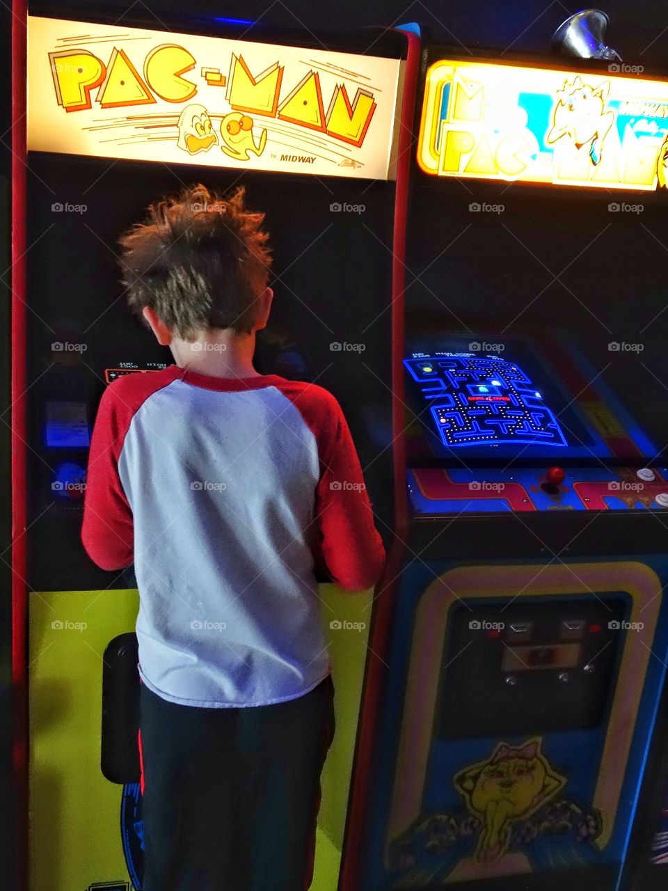 Boy Playing Vintage Video Game. Young Boy Playing Pac Man In 1980s Retro Arcade

