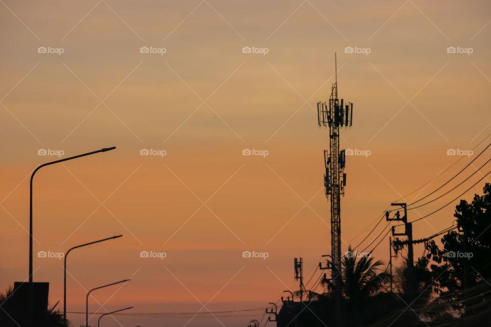 The sunrise in the morning is orange after the telephone receiver antenna.