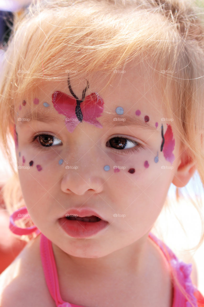 Little cute child making face paint