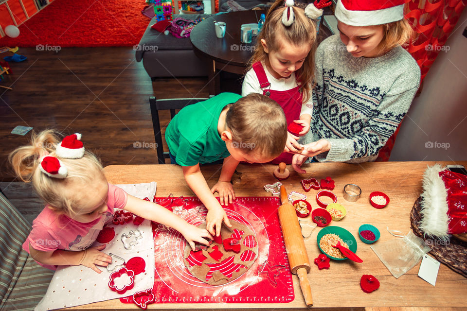 Baking Christmas cookies. Christmas gingerbread cookies in many shapes decorated with colorful frosting, sprinkle, icing, chocolate coating, toppers, put on table. Baking traditional cookies. Family celebrating Christmas. Baking at home
