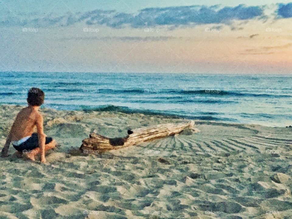 Boy on sunset beach