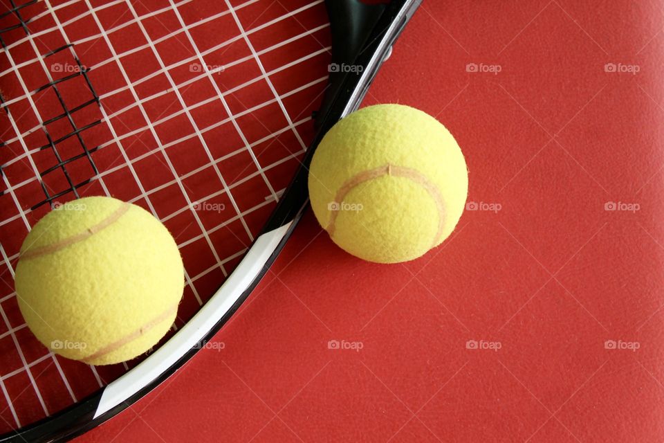 Tennis racket and ball on red background