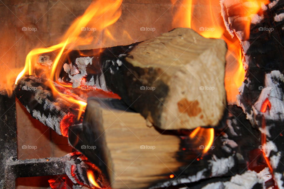 This is a up close picture of fire burning firewood in a fireplace during the cold winter.