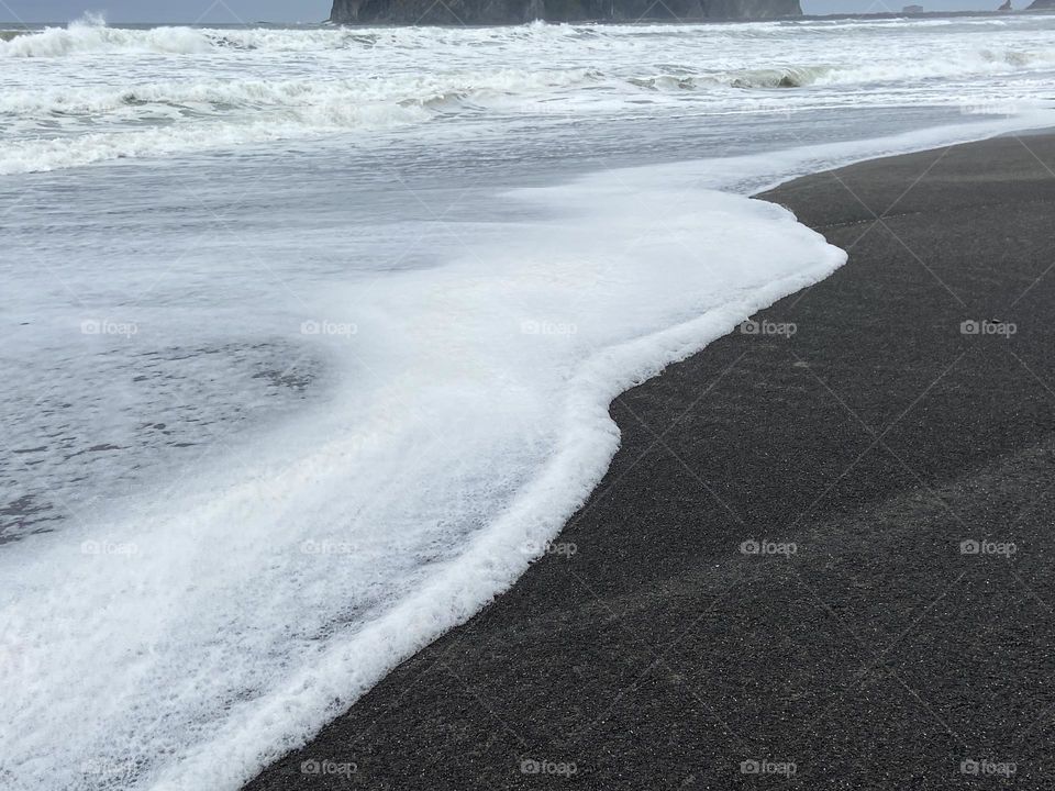 Sea foam crashing on the ocean beach