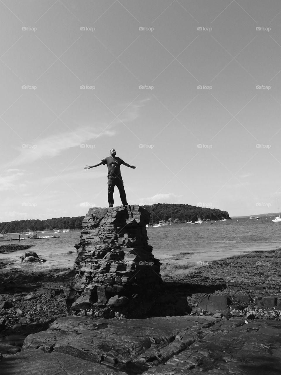 Happy grey story man on top of big rock 