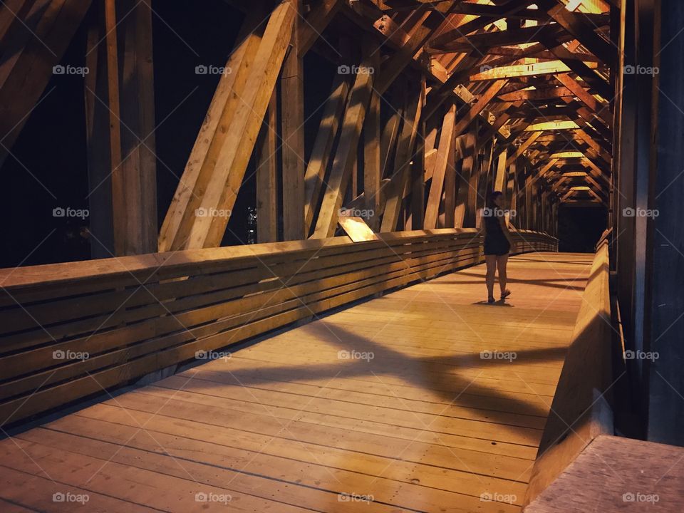 Walking across a wooden bridge on a warm night across the Kicking Horse River in Golden, British Columbia. 