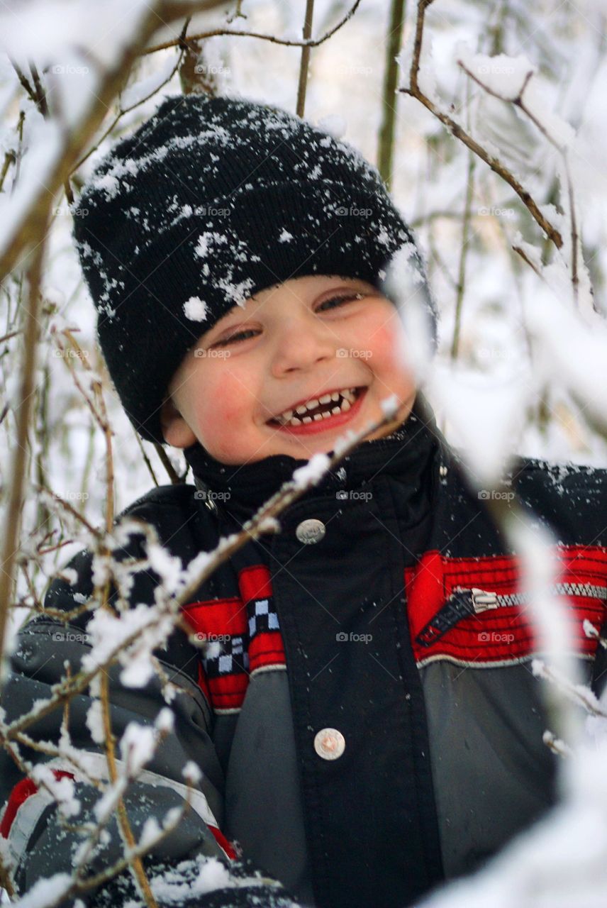 Portrait of a happy boy with snow