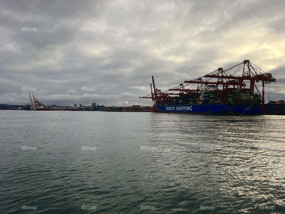 View of a cargo ship at the Vancouver Centerm Terminal from a SeaBus ferry crossing the Vancouver Harbour