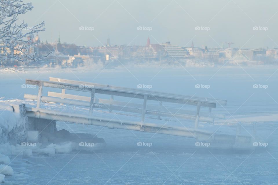 Ice covered floating pontoon loading dock by the icy Baltic sea in Helsinki, Finland.