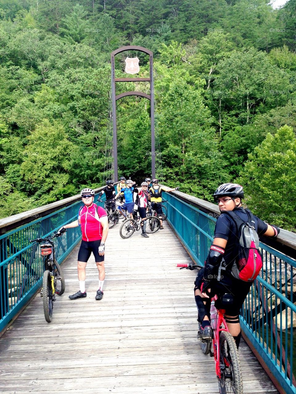 Friends on mountain bikes on a bridge