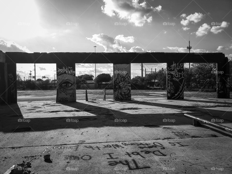 Black and white:  Abandoned remains of an urban building with street art at sunset creating shadows  and highlighting graffiti messages and art.