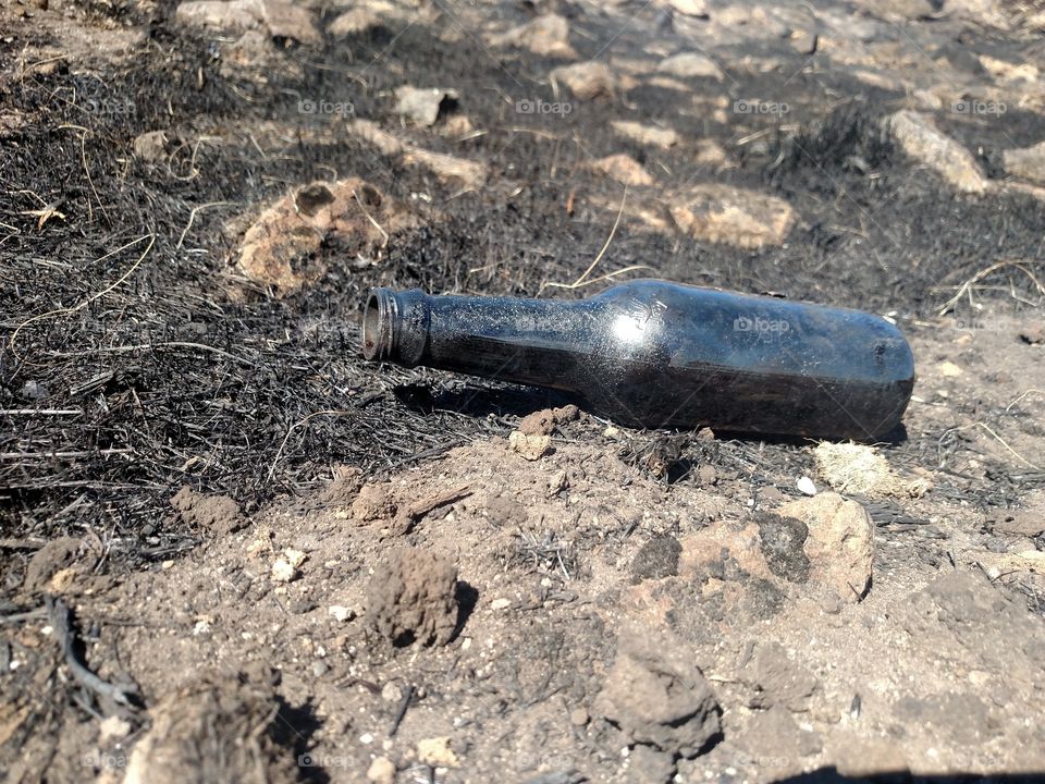 Black bottle in a burnt out area.