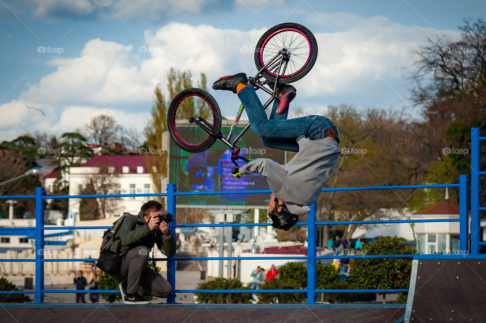 The cyclist performs a flip trick and at that moment the photographer takes it off
