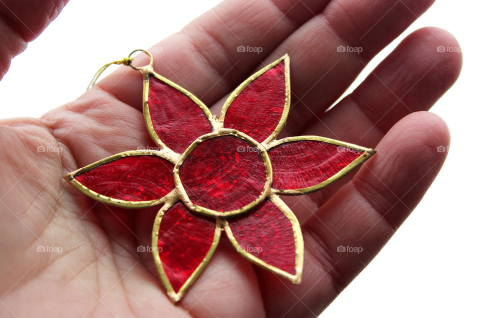 red and golden star lying in the palm of a hand