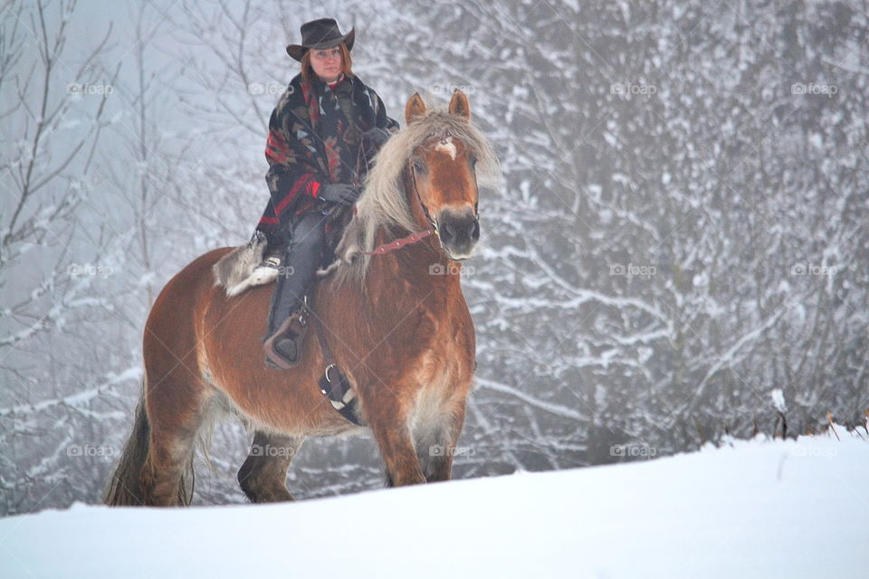 Girl riding her horse in the snow