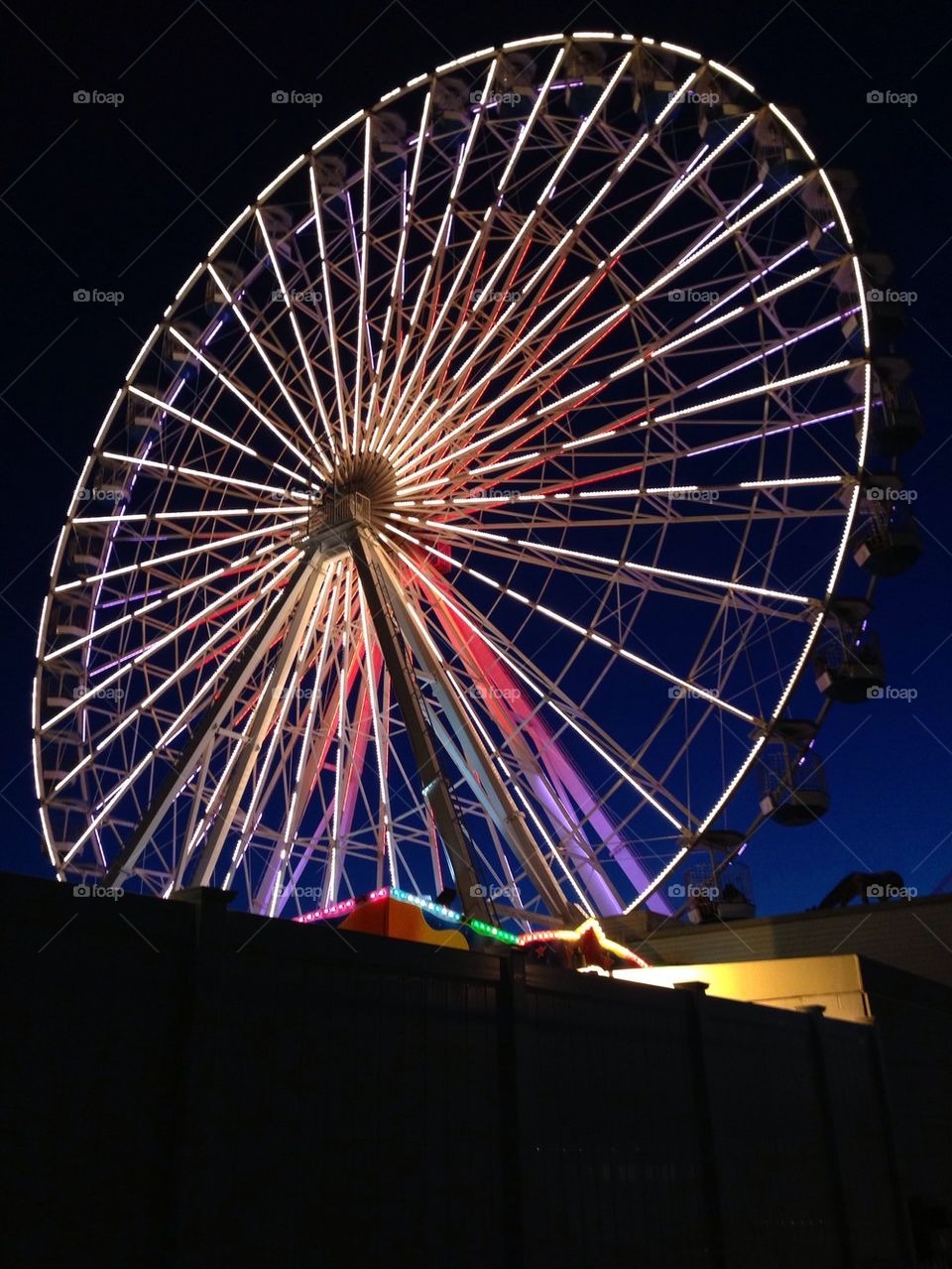 Ferris wheel against a dark blue sky.