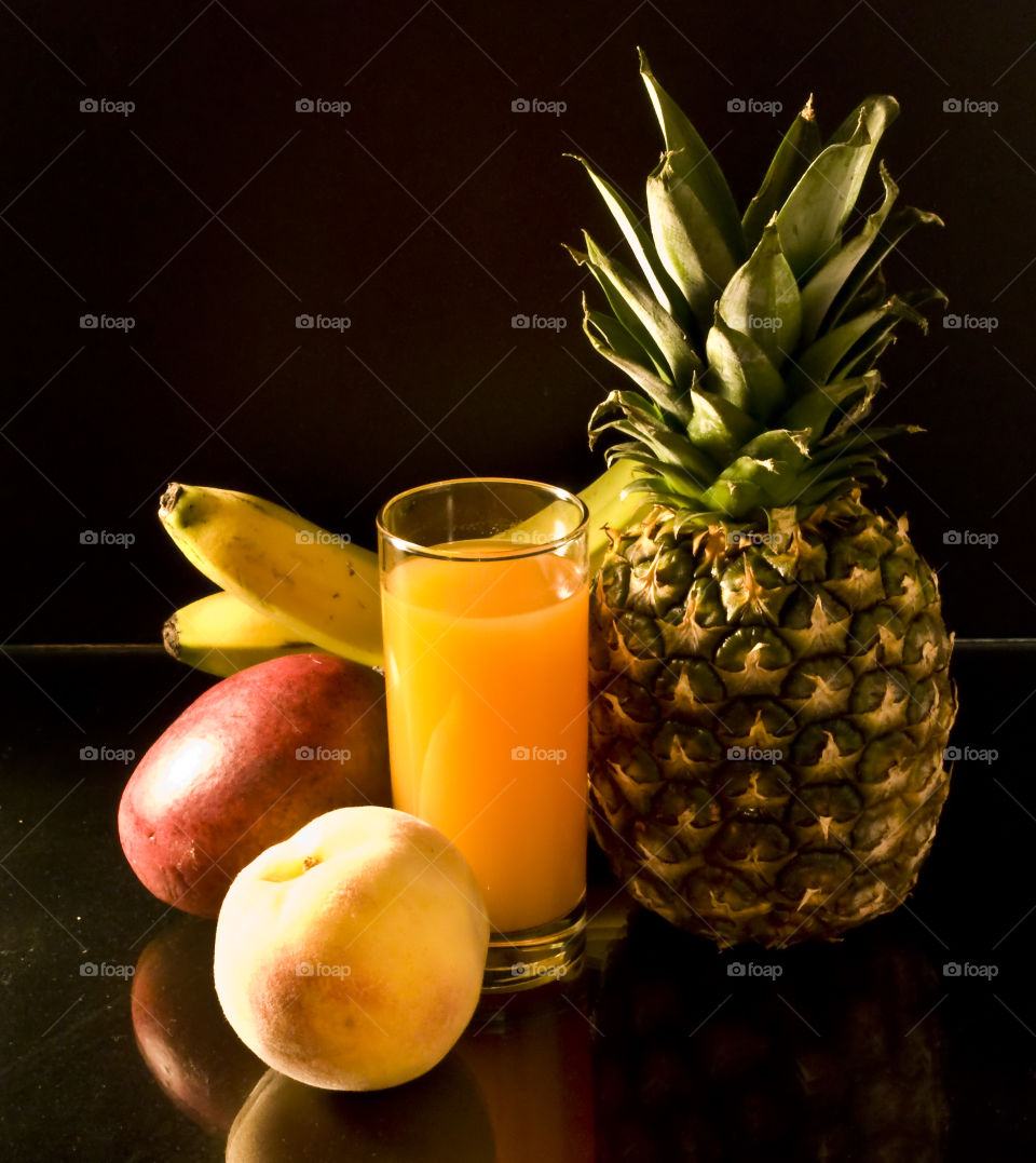 Various fruits and a glass of juice