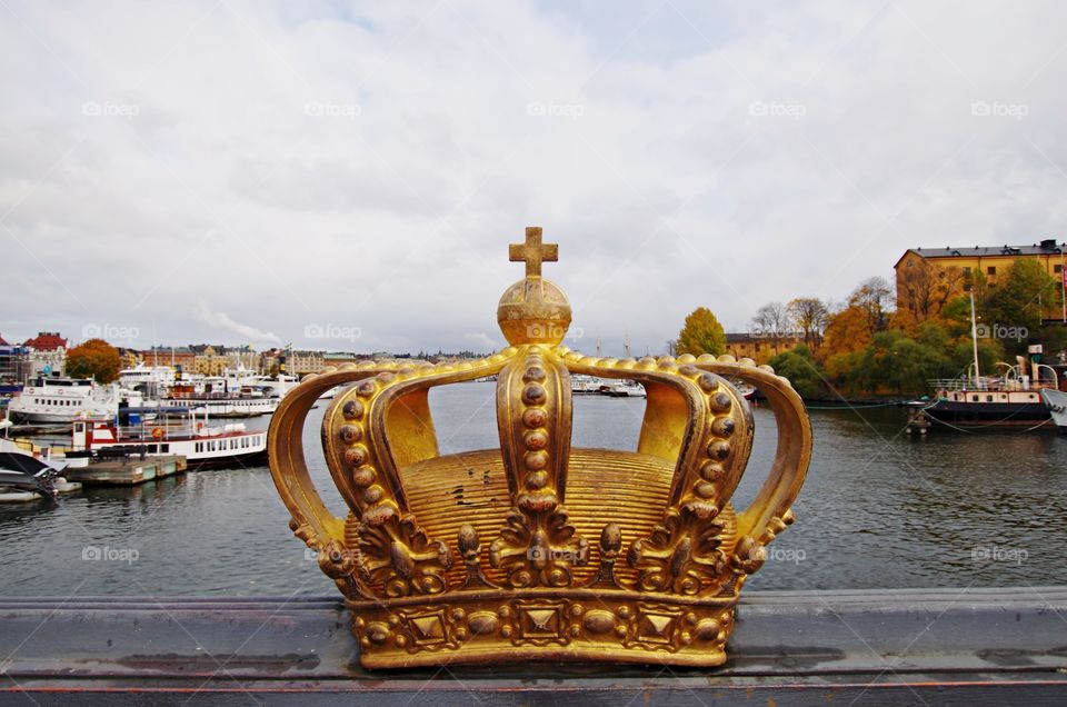 The royal gold crown on the skippsholm bridge with old town and ocean background. Autumn time.