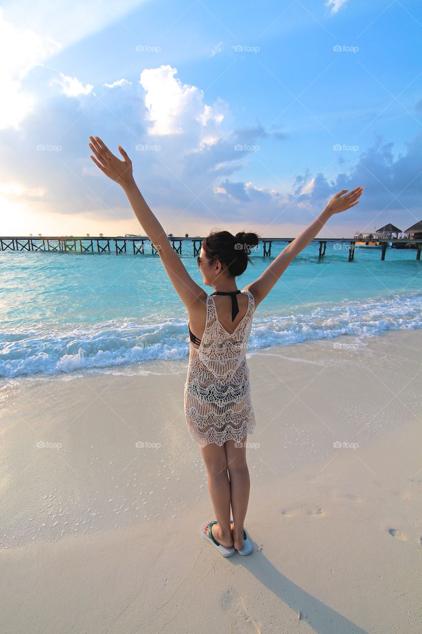 Happy Girl. A beautiful girl enjoying her honeymoon in Maldives under the setting sun