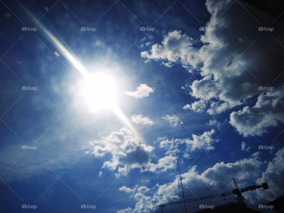 Blue sky, active clouds and bright sun with white light. We usually see this in the morning by the window.