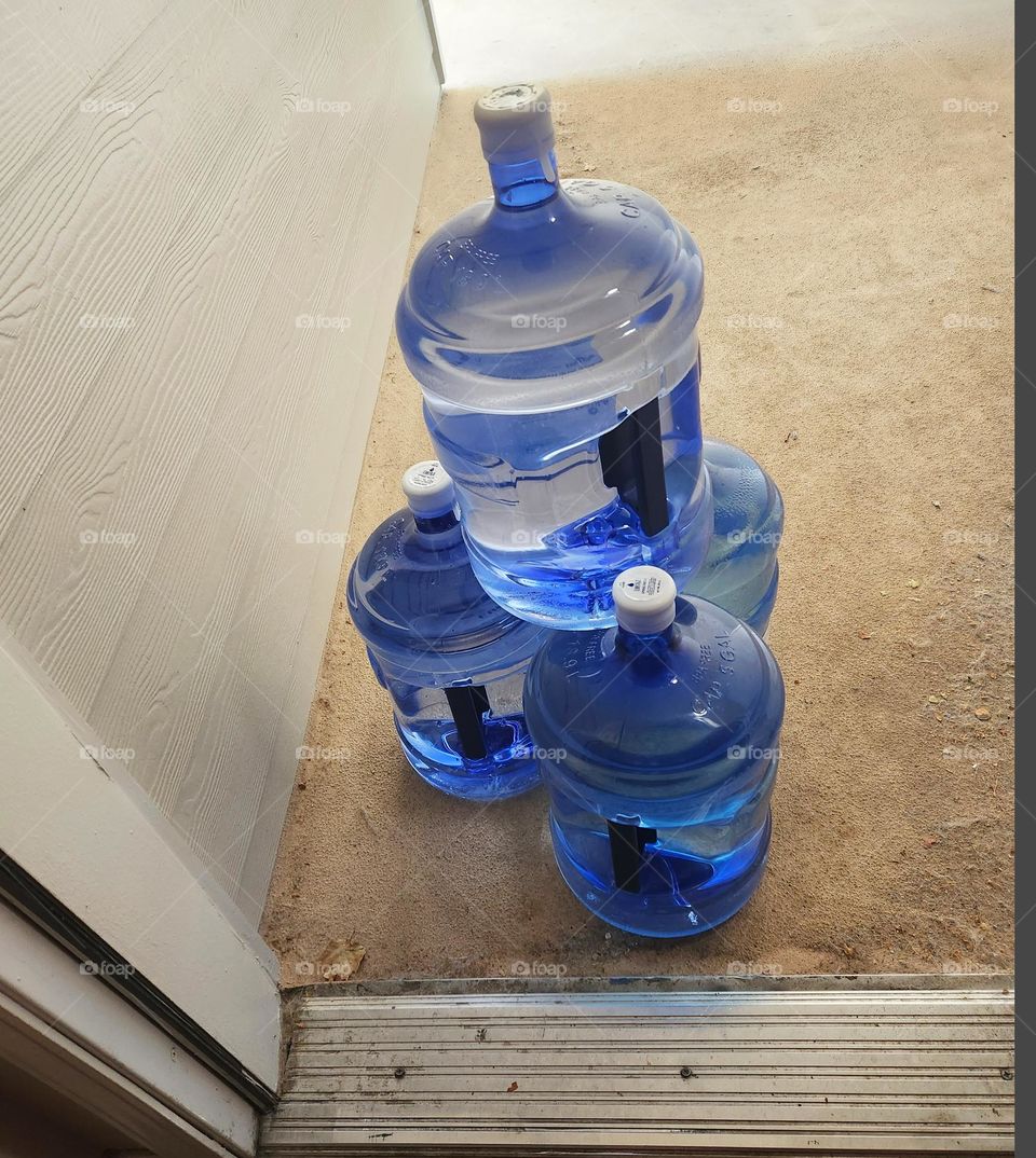 stacked water bottle delivery to a suburban apartment during hot Summer weather