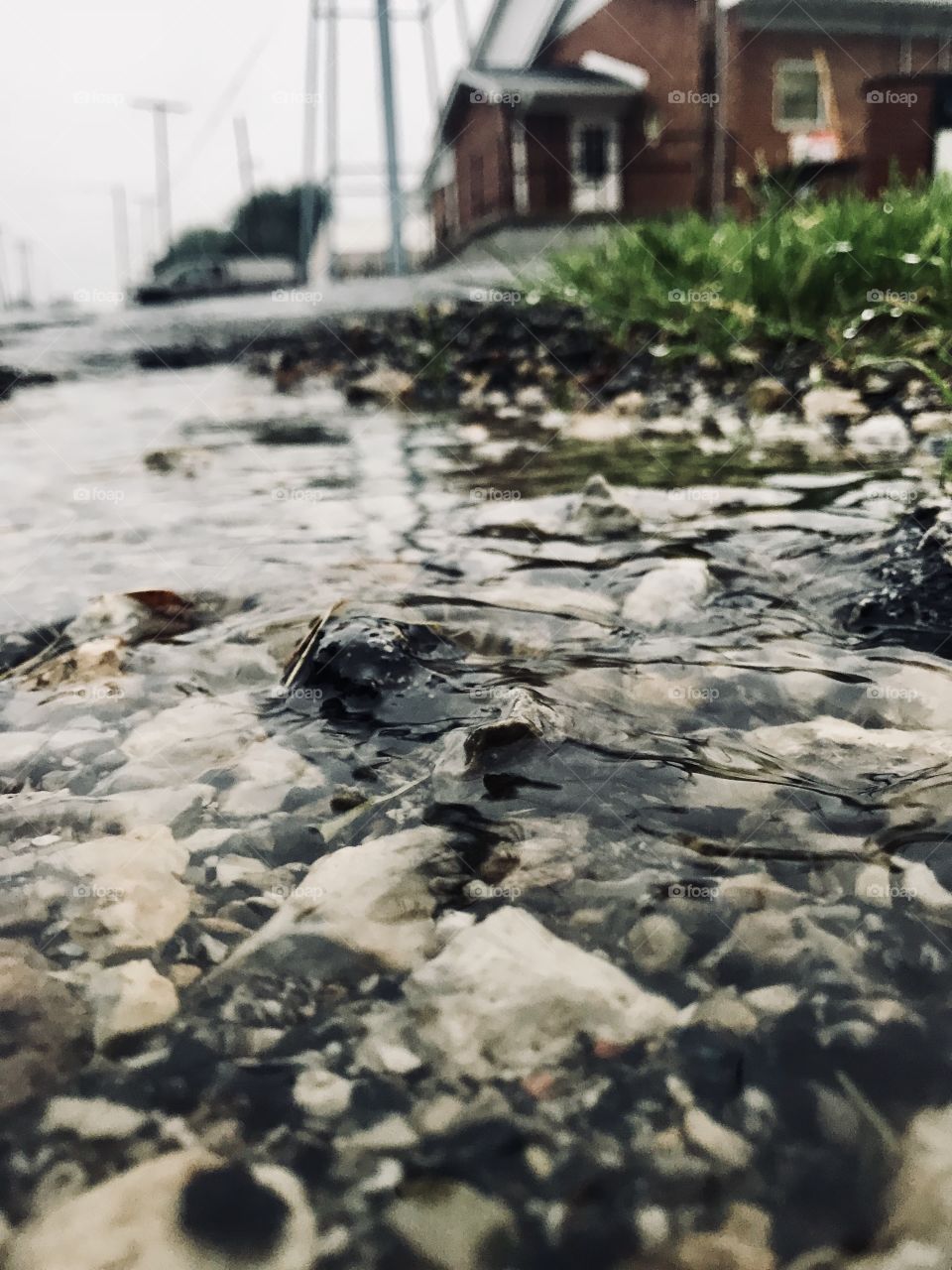 Stones along a road with water running away from them.
