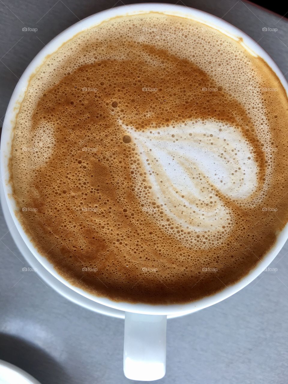 Loving coffee, white coffee cup of cafe latte heart shape closeup 