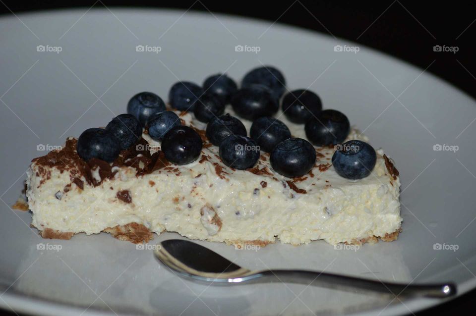 homemade cold cheesecake with grated chocolate and fresh blueberry