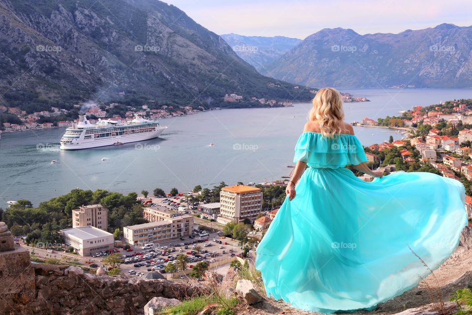 Lady in a turquoise dress on top of a mountain