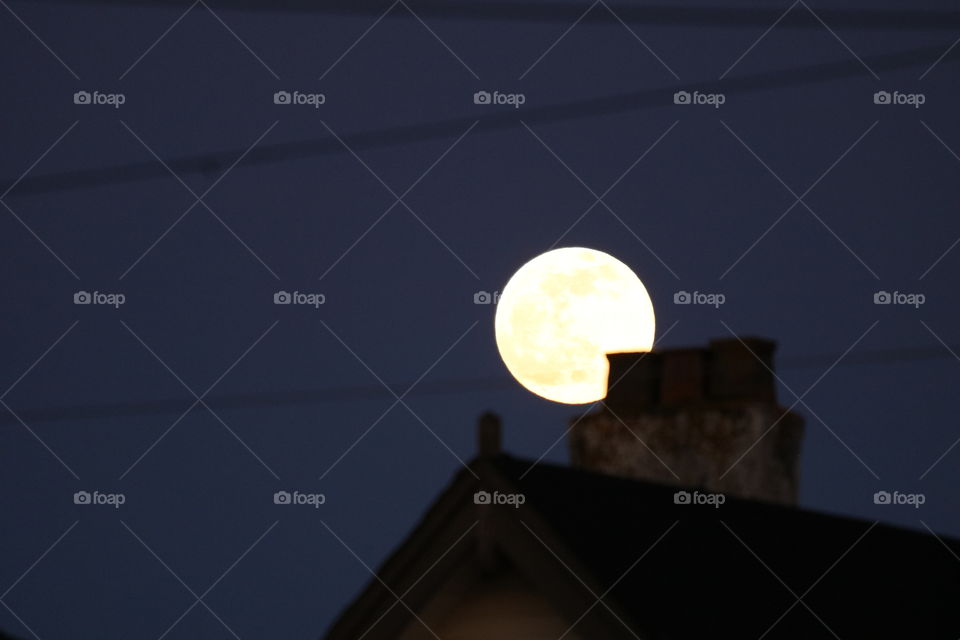 Full moon above the chimney in a chill winter night .. They also called it a snow moon