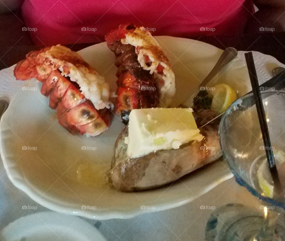 Lobster and baked potato loaded with butter