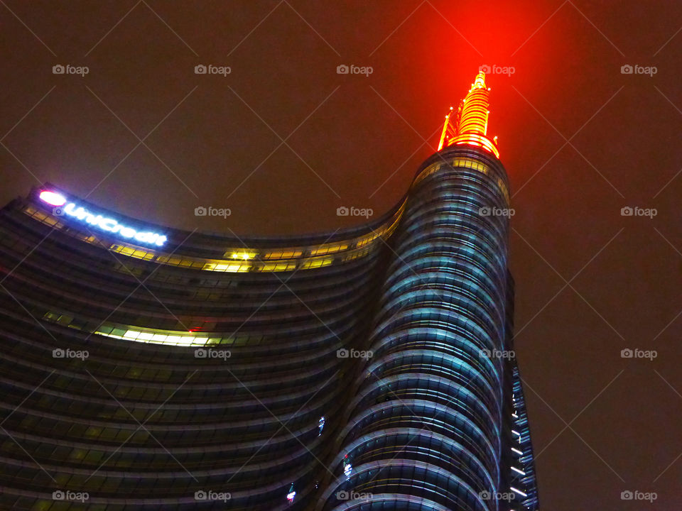 Illuminated spire of the skyscraper at night,Milan.Italy
