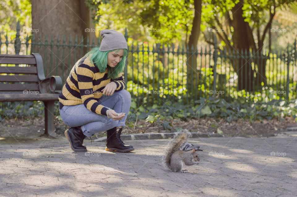 Girl with green hair feeding squirrel alternative girl in the park