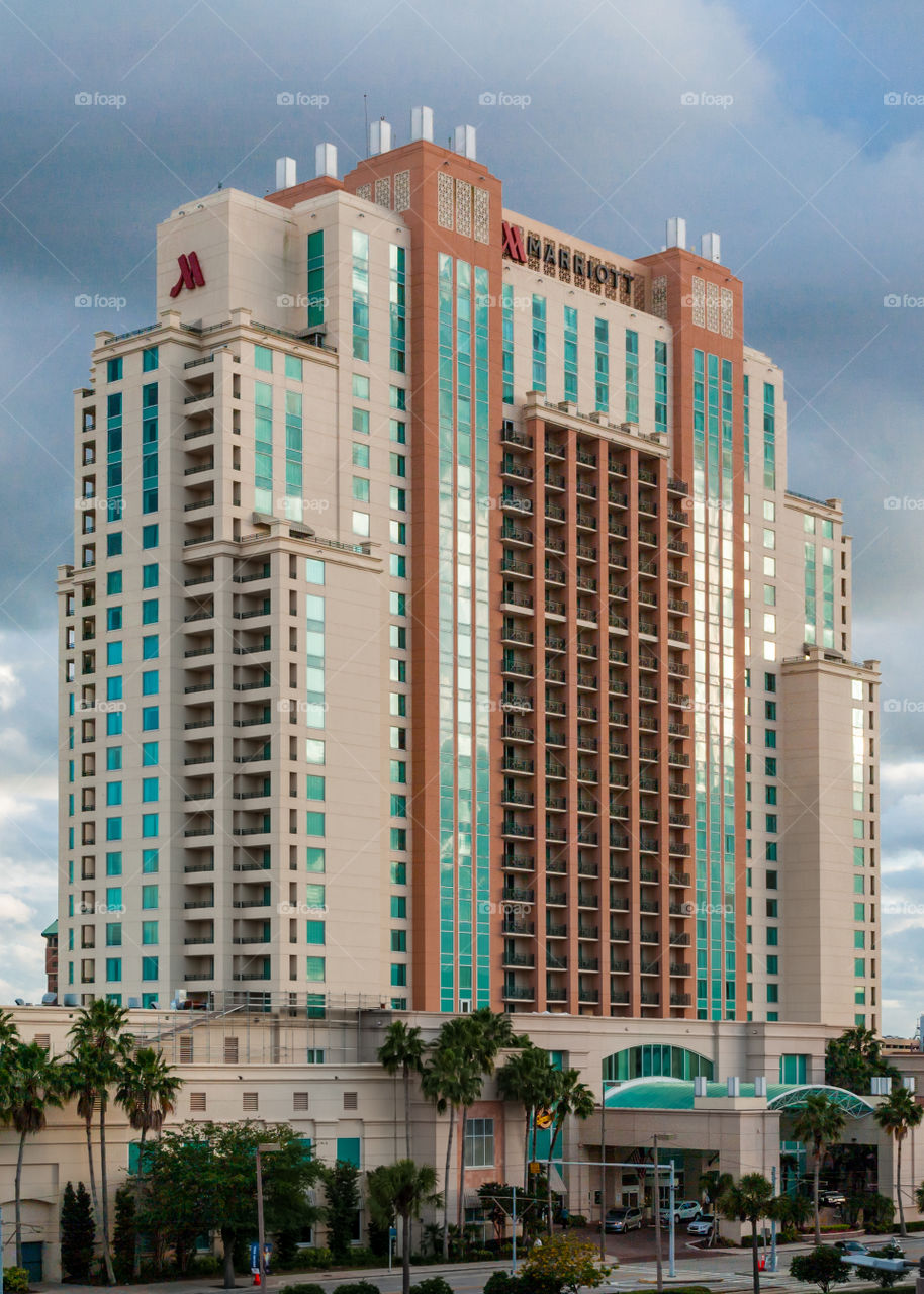 downtown building with orange and turquoise colors against a dark blue sky with white clouds