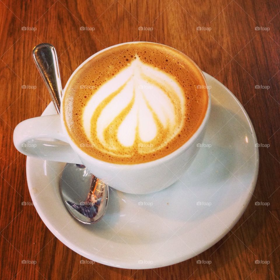 Espresso drink in white cup on wooden table