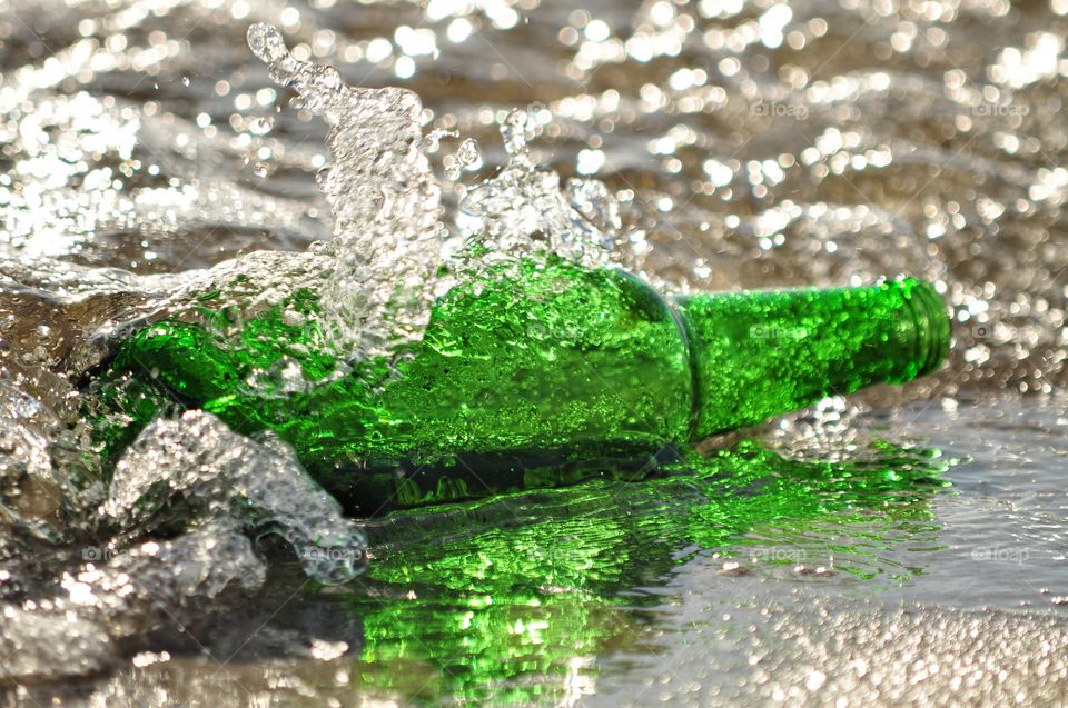 green bottle in the waves on the beach in Poland, the Baltic sea coast