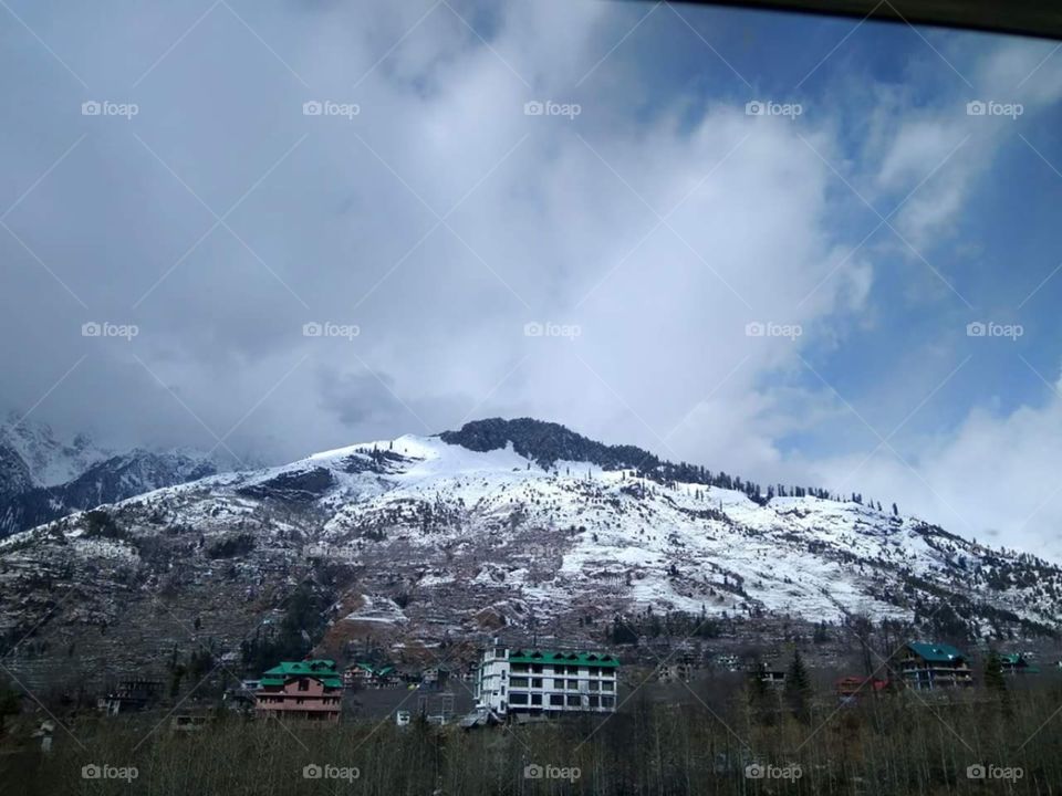 very big mountain covered with snow having so many trees and green grass are covered with snow looking very very beautiful. cold cold himachal