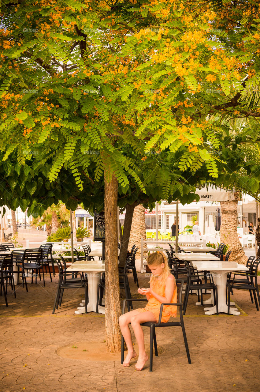 girl is sitting under the blooming tree