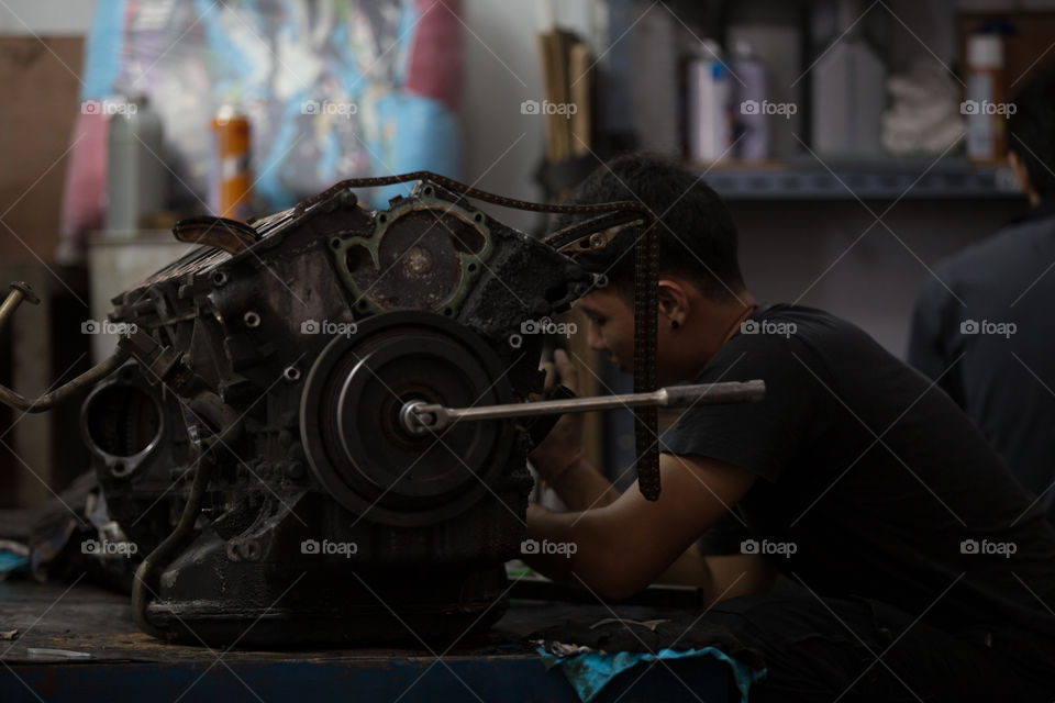 Technician fixing the car engine 