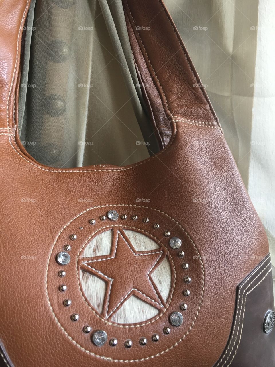 Cowhide purse with studded background 