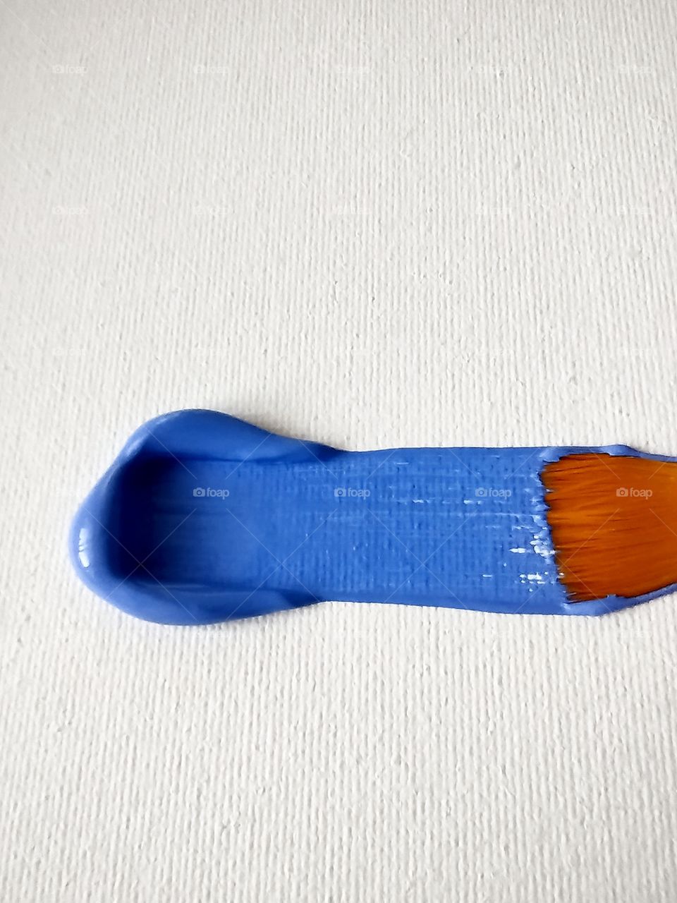 Unfiltered, beautiful, lovely close-up of a blue paint stroke and a paint brush