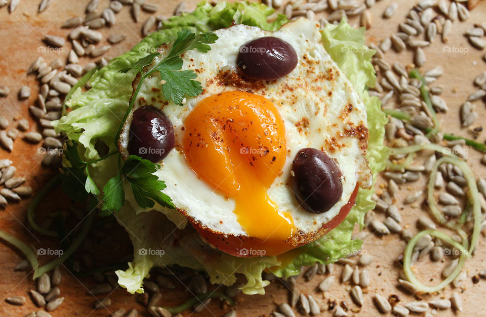 Tasty burger with fried egg, olives, lettuce, seeds, home made