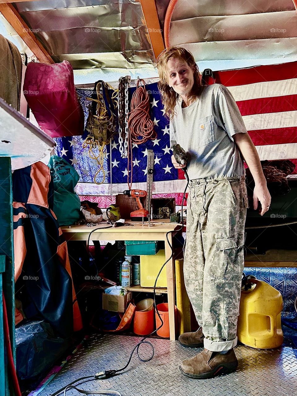 This is „Timothy Trespas“, my partner in life for many many years in his workshop aboard „Salvation“, our „28 ft 1969 Luhrs“ cabin cruiser at „Newtown Creek“ in LIC, Queens working on a project. 2023. Hypnotic Productions