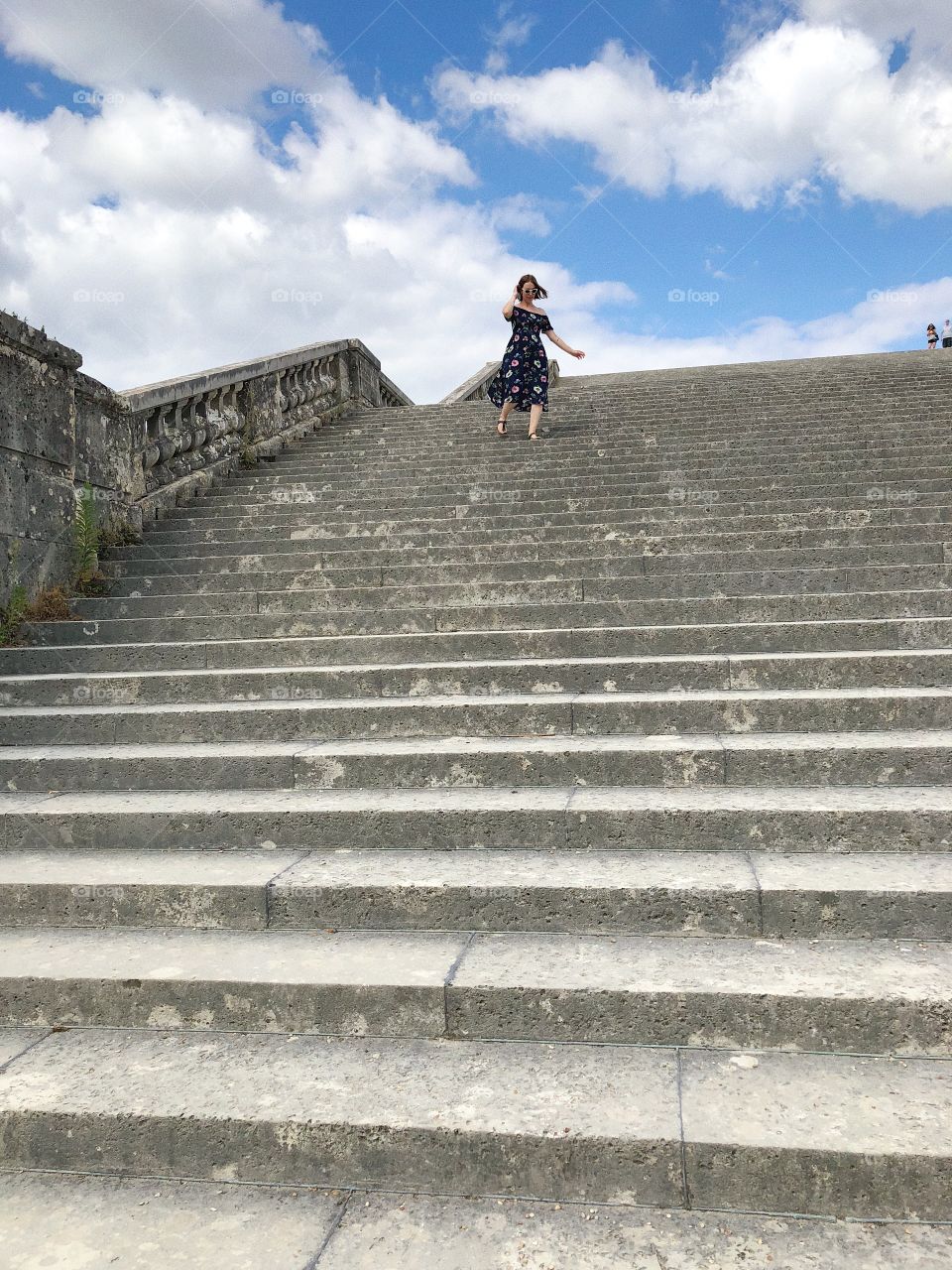 Woman running down steps at Versailles 
