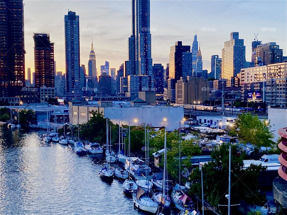 This is the view of “Newtown Creek” from the “Pulaski Bridge” on a balmy Indian summer evening in October 2023. You can see the boats that are tied to the shore as well as the combined skyline of LIC, Queens and “Manhattan”.  Hypnotic Productions