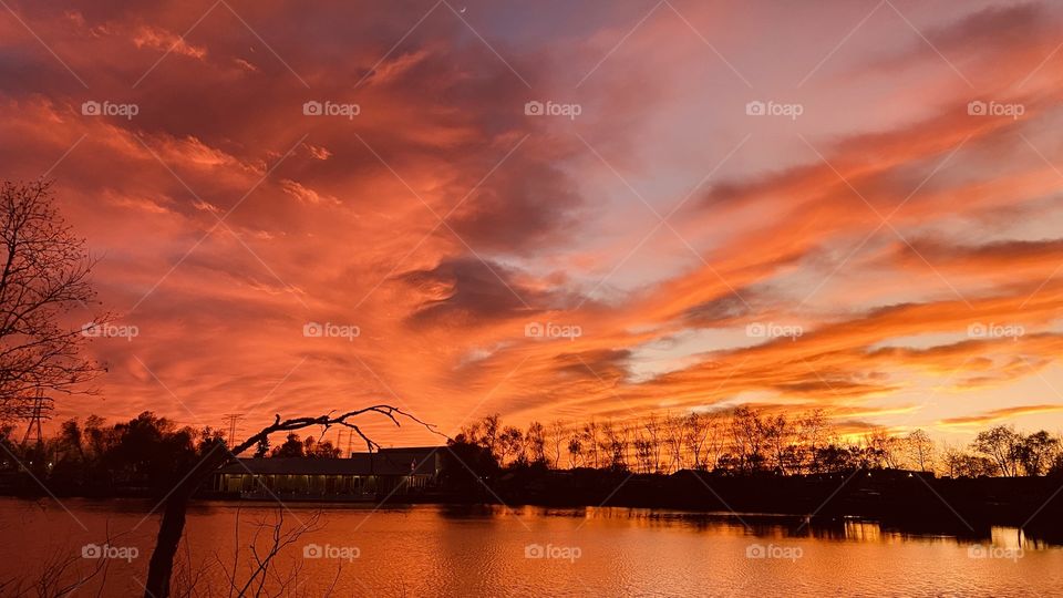 Deep Sunset Colors is upon the Beautiful Sunset also sky reflections silhouetted across colorful Lake waters. 